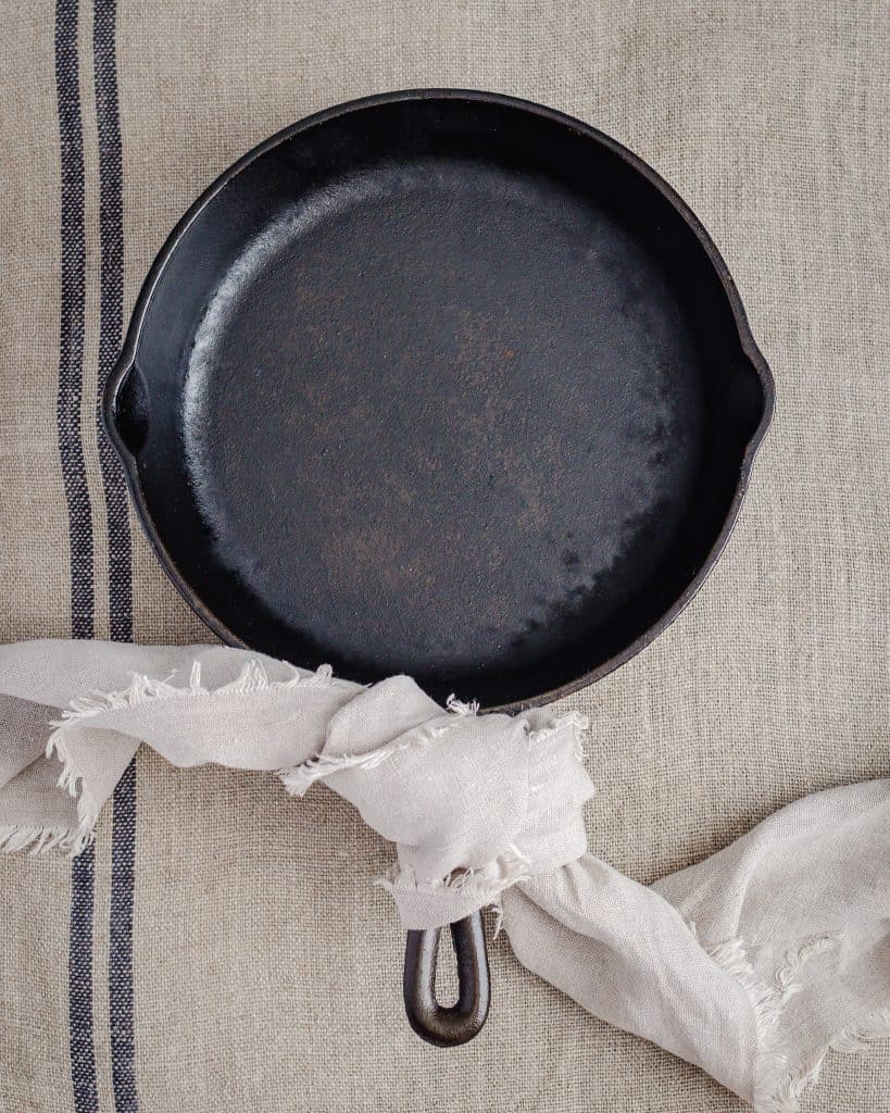 A lodge seasoned, cast iron skillet with a linen tea towel around the handle. Image by Emma Lee - The Irishman's Wife
