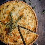 caramelized onion and goats cheese tart with a slice cut ready to serve