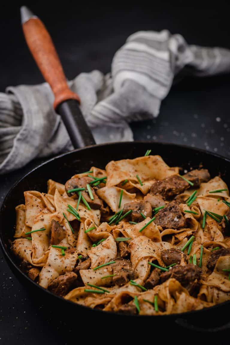 frypan of slow cooked beef stroganoff with black pepper pappardelle