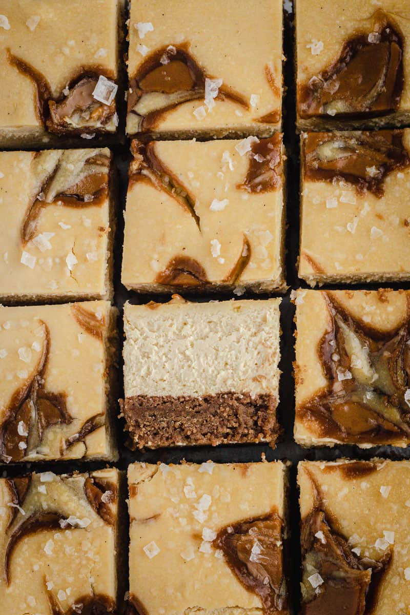 squares of baked biscoff cheesecake slice. One slice is showing the filling center