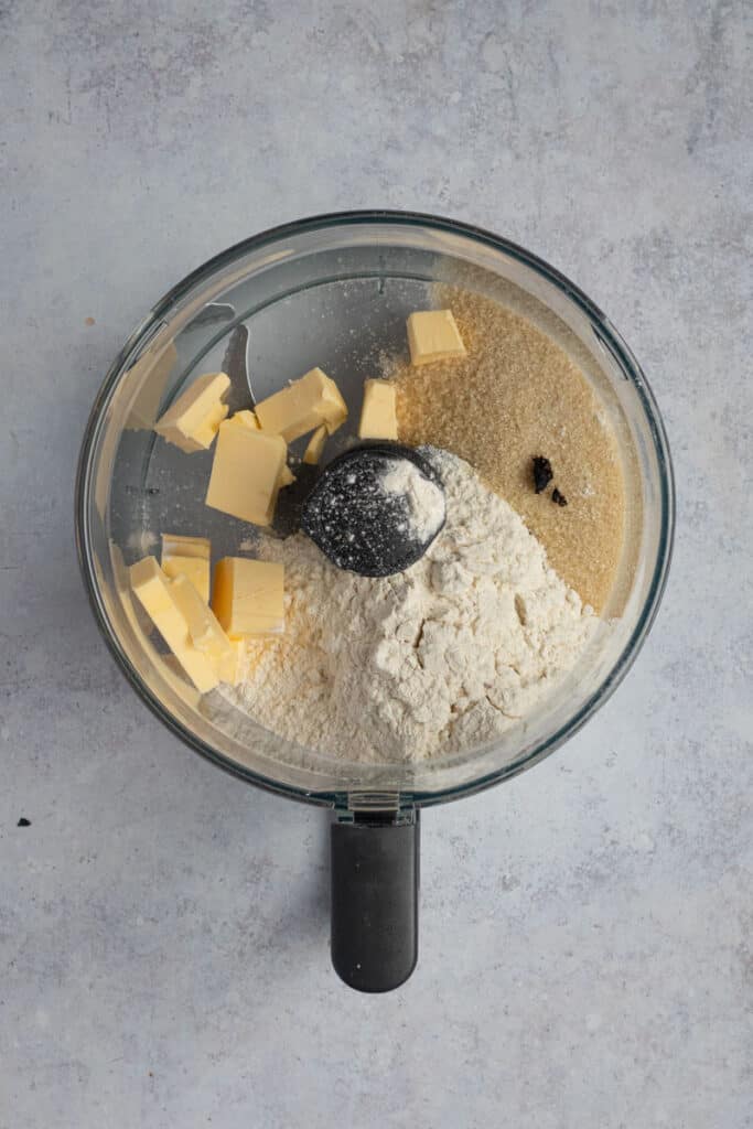 A mulipurpose blade in a food processor with the crumble topping ingredients.