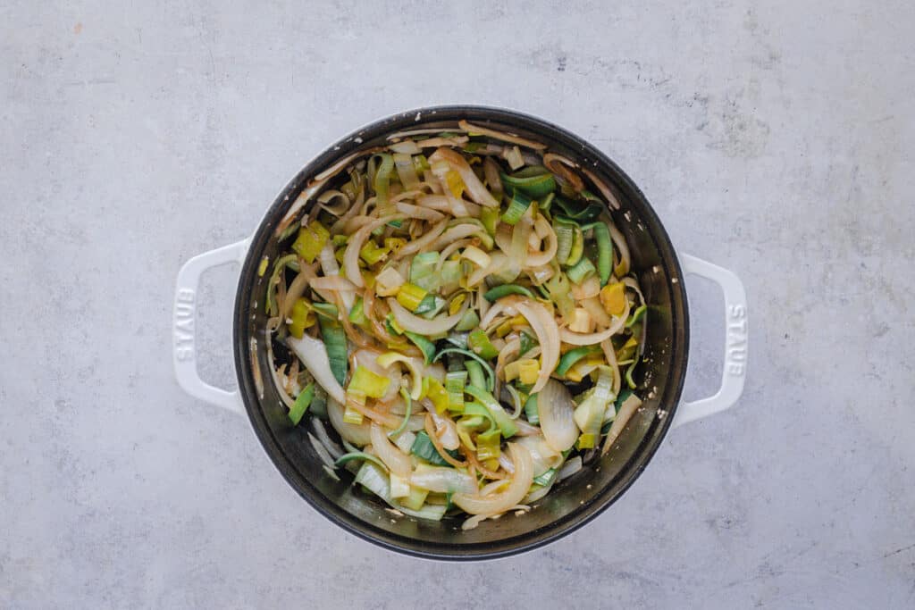 Sliced leeks and onions sauteed in in pot in a little oil.