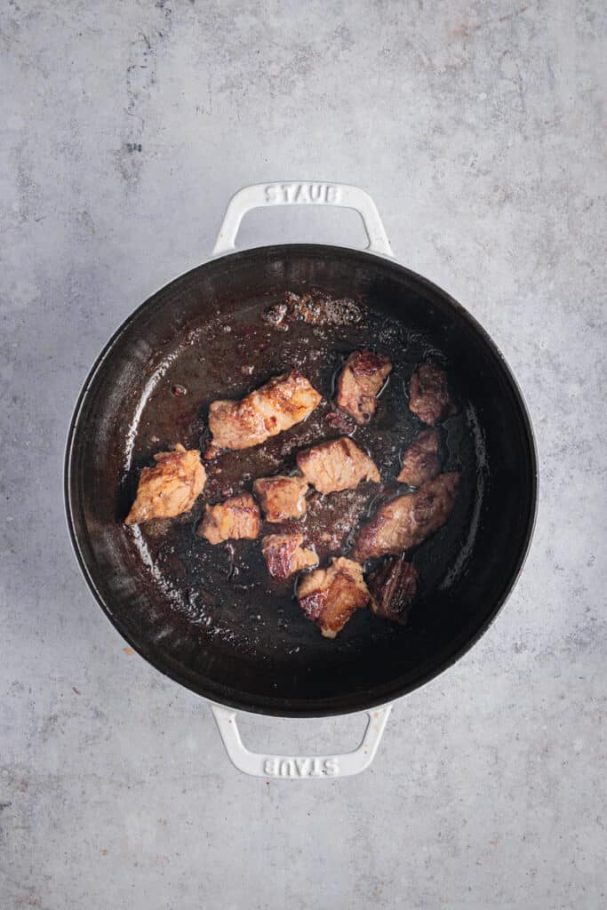 Meat browning in a cast iron pot.