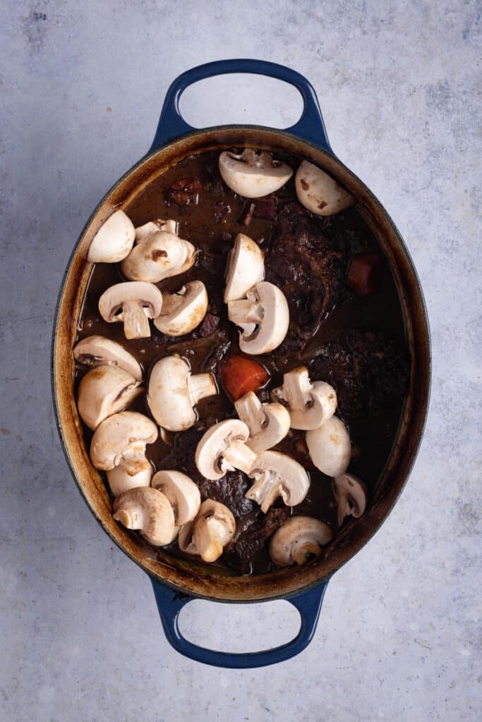 Add mushrooms to the pot and return to the oven.