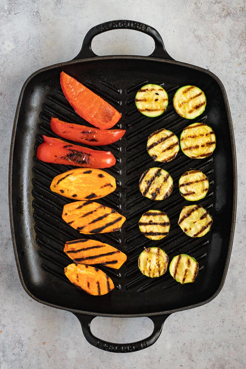 Grilled vegetables on a black Le Creuset grill pan.